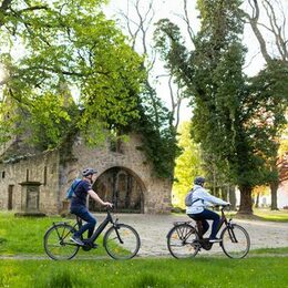 Radfahrende vor der Vöppstedter Ruine in Salzgitter-Bad.